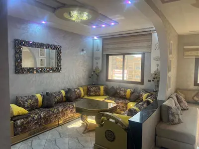 a living room with a couch and a table at Apparemment 3 chambre in Oulad Akkou