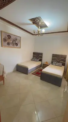 a room with two beds and a ceiling at البستان in Oulad Akkou