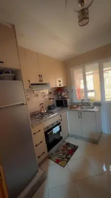 a kitchen with a refrigerator and a stove top oven at البستان in Oulad Akkou