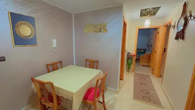 a dining room with a table and chairs and a hallway at البستان in Oulad Akkou
