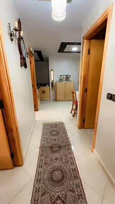 a hallway with a rug on a tiled floor at البستان in Oulad Akkou