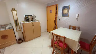 a dining room with a table and a refrigerator at البستان in Oulad Akkou