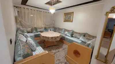 a living room with a couch and a table at البستان in Oulad Akkou