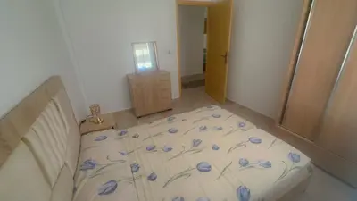 a bedroom with a bed with blue flowers on it at البستان in Oulad Akkou