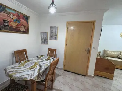 a room with a table and a bed and a door at البستان in Oulad Akkou