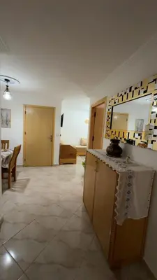 a living room with a table and a mirror at البستان in Oulad Akkou