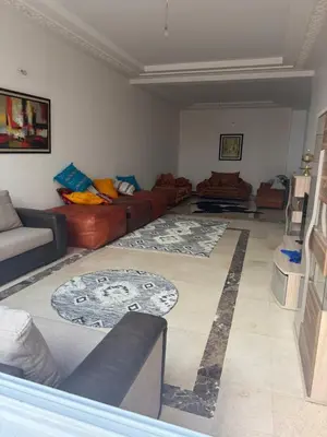 a living room with couches and a rug at Champ de course in Oulad Akkou