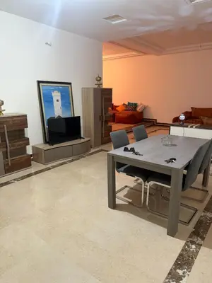 a living room with a table and a tv at Champ de course in Oulad Akkou