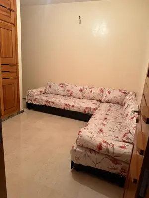 a living room with a couch in the corner at Champ de course in Oulad Akkou