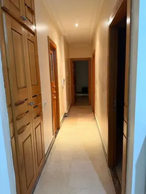 a hallway with wooden doors and a tile floor at Champ de course in Oulad Akkou
