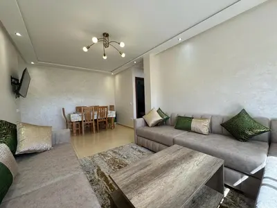 a living room with a couch and a table at Appartement de luxe in Ifrane