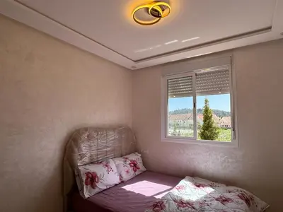 a small bedroom with a bed and a window at Appartement de luxe in Ifrane