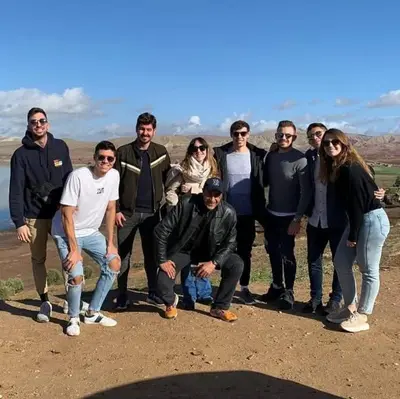 a group of people posing for a picture on a hill at Mom's food in Oulad Akkou