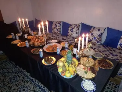 a table with candles and plates of food on it at Mom's food in Oulad Akkou