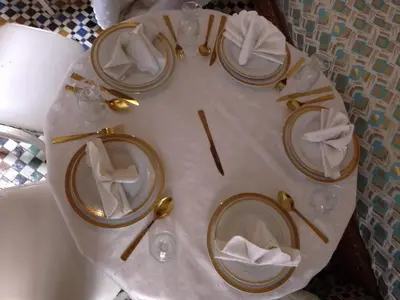 a white table with plates and napkins on it at Mom's food in Oulad Akkou