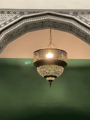 a chandelier hanging from a ceiling in a building at Dar Drouj a Special 14th Century Familyhouse Riad in Fès
