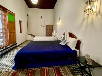 a bedroom with a blue bed in a room at Dar Drouj a Special 14th Century Familyhouse Riad in Fès