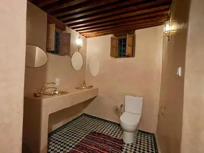 a bathroom with a toilet and a sink and mirror at Dar Drouj a Special 14th Century Familyhouse Riad in Fès