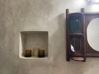 a mirror on a wall with two candles on a shelf at Dar Drouj a Special 14th Century Familyhouse Riad in Fès