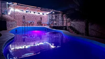 a swimming pool at night with purple lights at Riad IZRAREN in FIGUIG in Zenaga