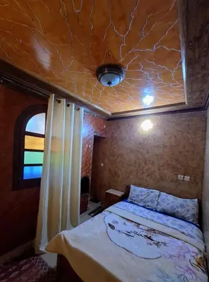 a bedroom with a bed and a coffered ceiling at Riad IZRAREN in FIGUIG in Zenaga
