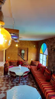 a living room with a couch and a table at Riad IZRAREN in FIGUIG in Zenaga