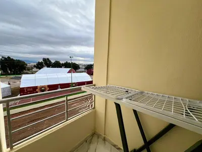 a balcony with a bed and a train out the window at Modern Apartment Fes Near Marjane & Old Medina in Fès