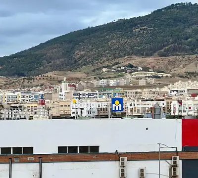 a view of a city with buildings and a mountain at Modern Apartment Fes Near Marjane & Old Medina in Fès