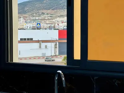 a window with a view of a parking lot at Modern Apartment Fes Near Marjane & Old Medina in Fès