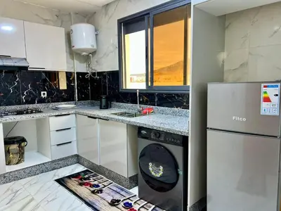 a kitchen with a refrigerator and a dishwasher at Modern Apartment Fes Near Marjane & Old Medina in Fès