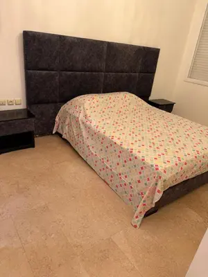 a bedroom with a bed with a head board at Champ de course in Oulad Akkou