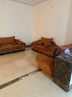a living room with two couches and a table at Champ de course in Oulad Akkou