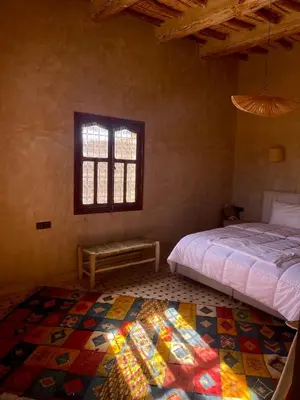 a bedroom with a bed and a window and a rug at Ranch Skouraya in Tajante