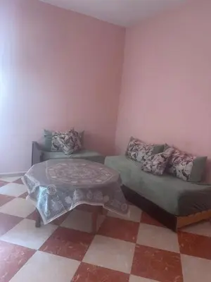 a room with two beds and a table at Kawtar in Meknès