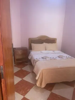 a bedroom with a bed and a tiled floor at Kawtar in Meknès