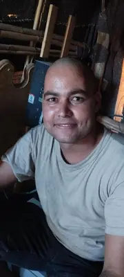 a man in a white shirt smiling at the camera at Desert Hassi labiad Camp in Merzouga