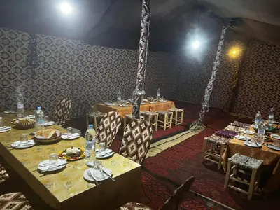 a dining room with tables and chairs in a tent at Desert Hassi labiad Camp in Merzouga