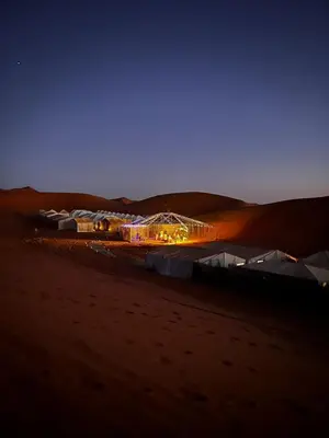 a group of tents in the desert at night at Desert Hassi labiad Camp in Merzouga