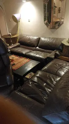 a living room with a leather couch and a table at Houria in Oulad Akkou