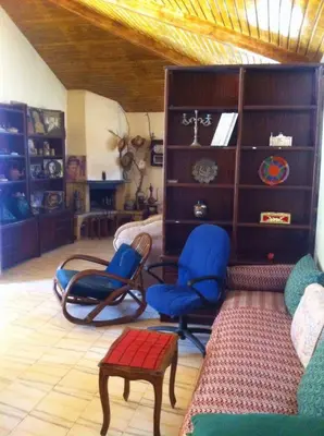 a living room with two blue chairs and a table at Houria in Oulad Akkou
