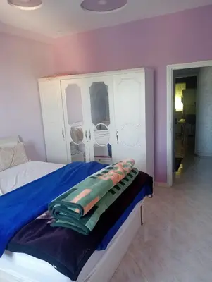 a bedroom with a bed with a blue blanket on it at Malak in Taza