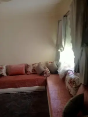a living room with a red couch and a window at Malak in Taza