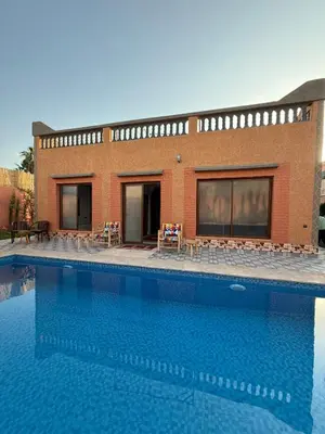 a building with a large swimming pool in front of it at Marrakech Private Villa with Pool, Near Ourika and Atlas Mountain in Aghmat