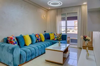 a blue couch with colorful pillows in a living room at Elegance in Oulad Akkou