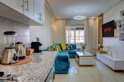 a kitchen and living room with a blue couch at Elegance in Oulad Akkou
