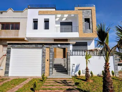 a white house with a garage and palm trees at Yacout 1 in Fès