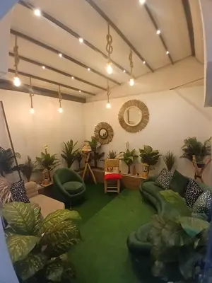 a living room with a green carpet and plants at Yacout 1 in Fès