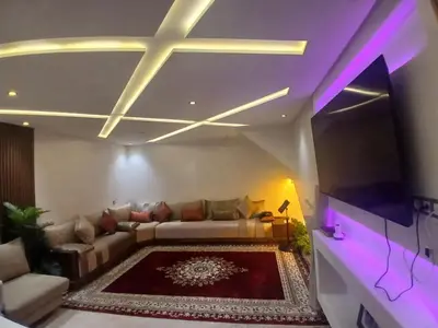 a living room with a couch and purple lighting at Yacout 1 in Fès