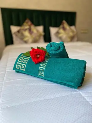 a bed with two towels and two roses on it at Villa Tounaroz in Marrakech
