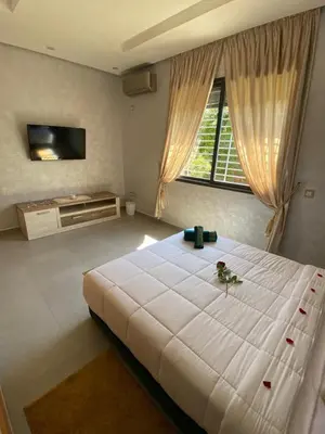 a bedroom with a large white bed and a window at Villa Tounaroz in Marrakech